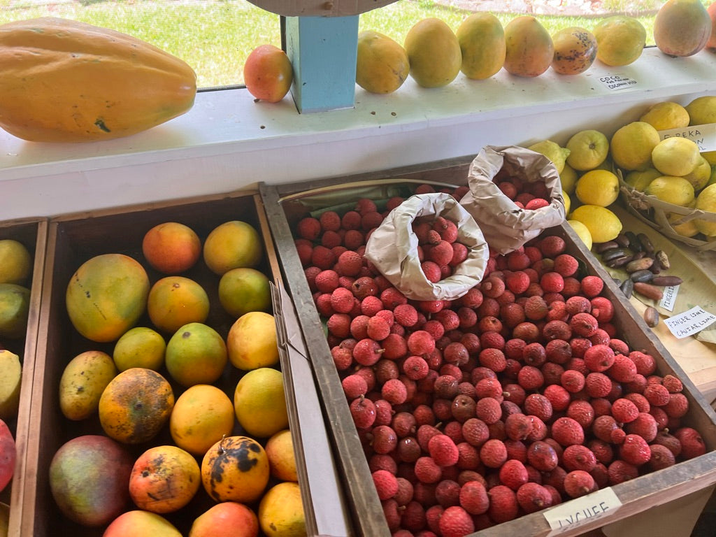 fruit displayed on a table on Kauai at 'Ohi 'Ohi Shop including lychee, mango, papaya, lemons and finger lime