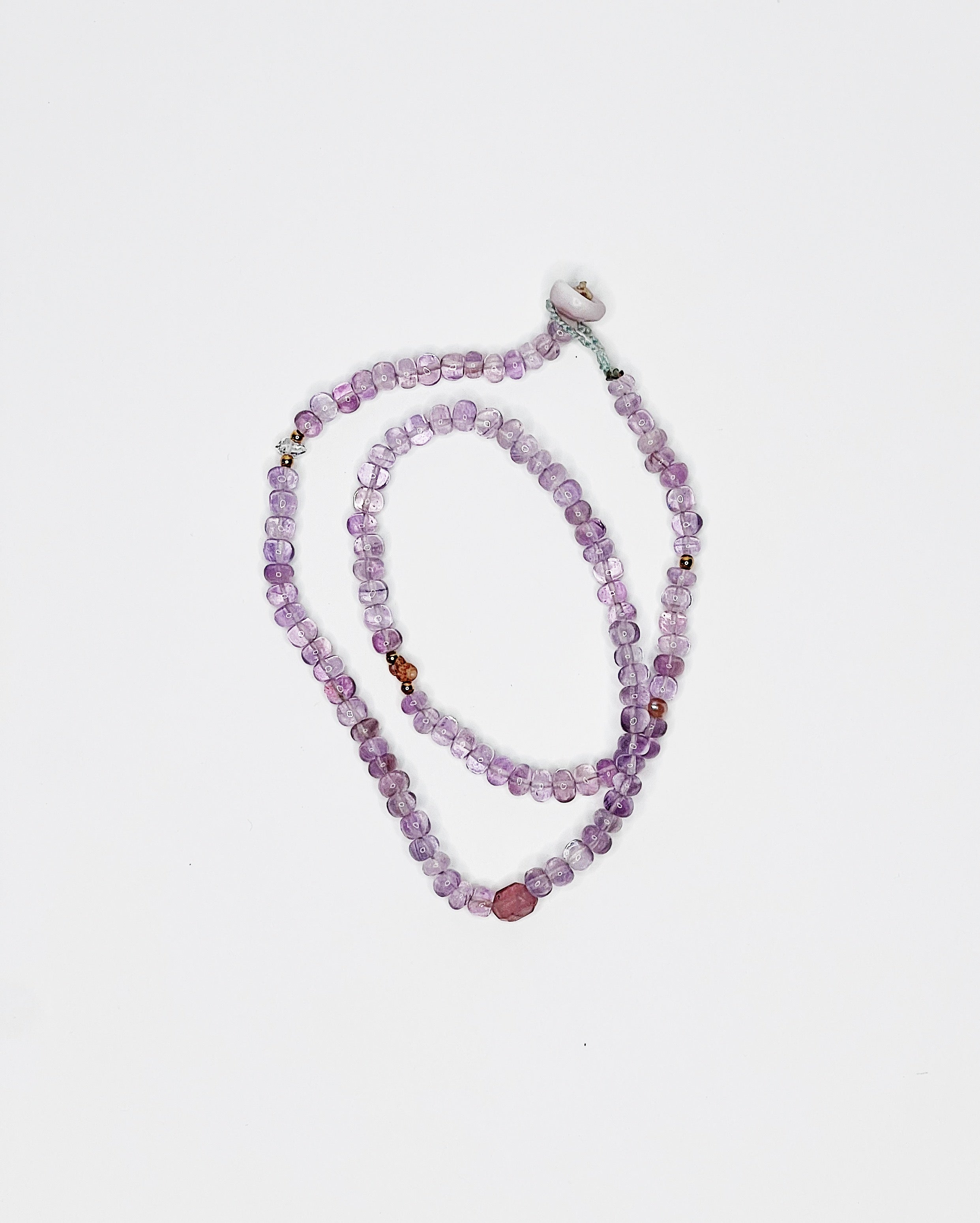 Handmade amethyst choker with Kahelelani shell and tourmaline accents, finished with puka shell clasp. White background