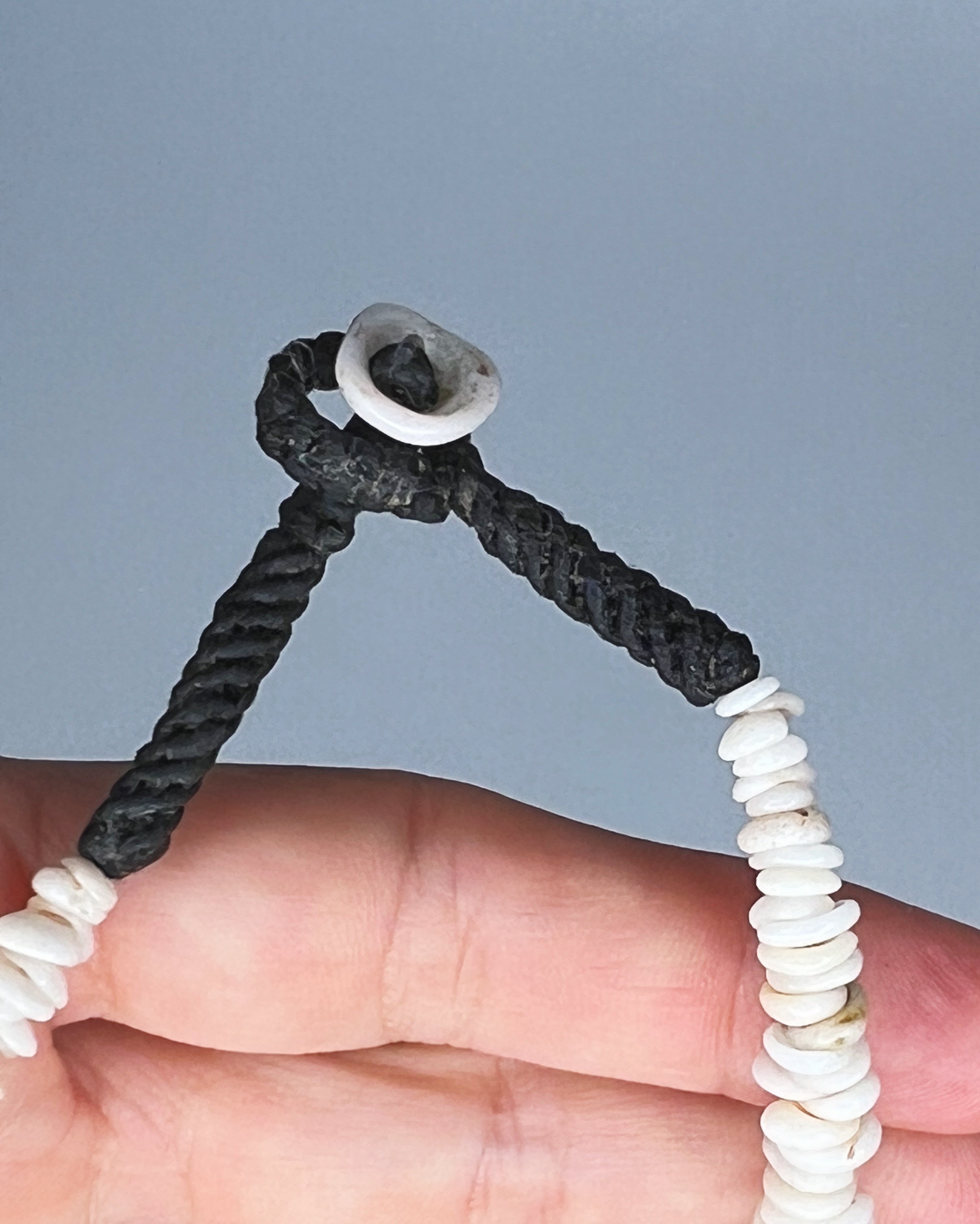 Close up of hand showing puka shell clasp