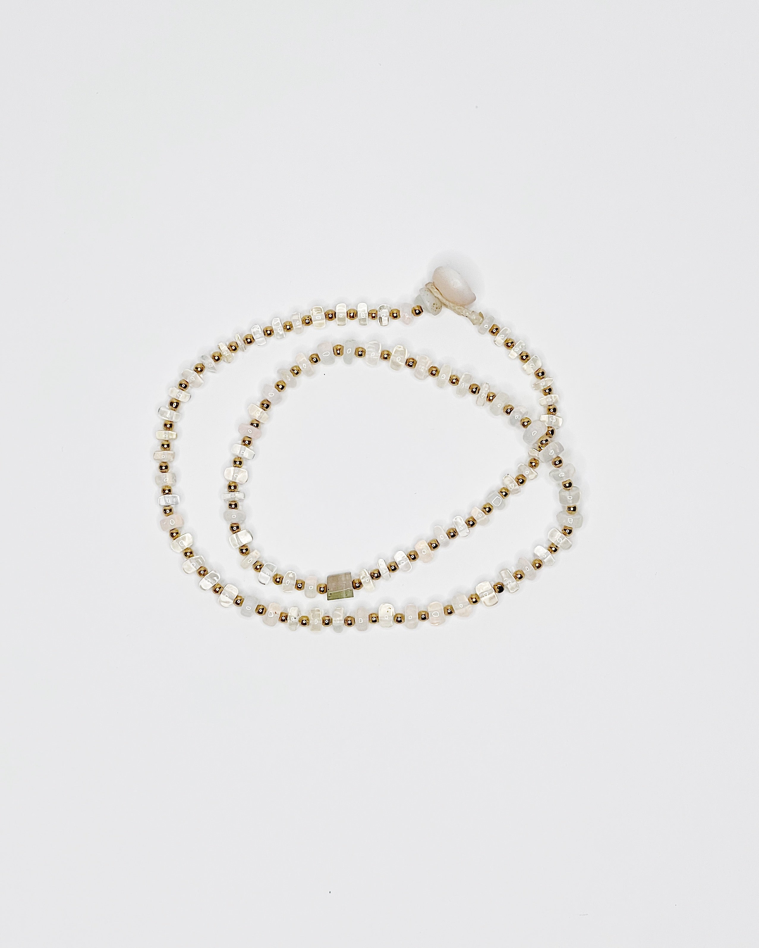 Handmade opal choker with colorful tourmaline accent, gold spacer beads, puka shell clasp, white background 