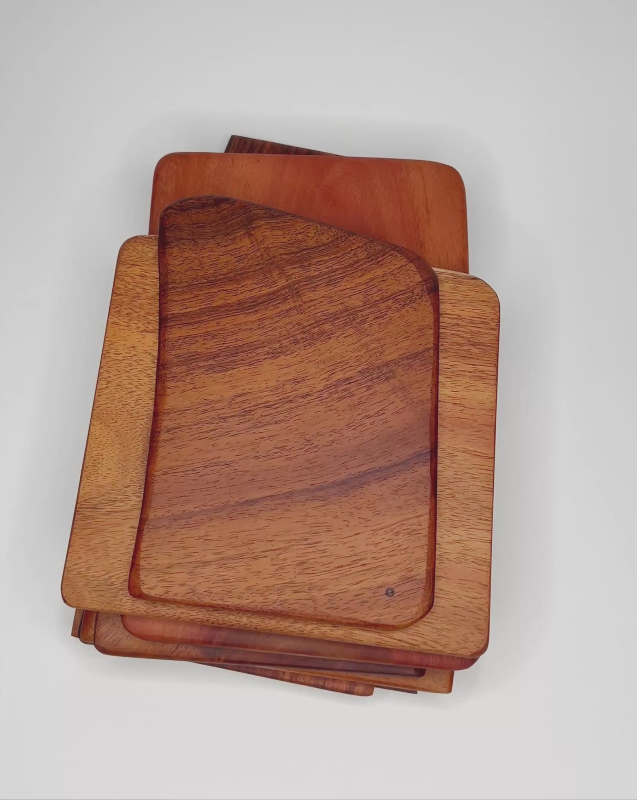 Movie of hands showing each of the Hawaiian hardwood picnic cutting boards. White background 